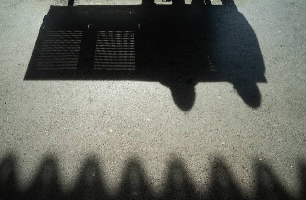 Shadows of people sat on a bench